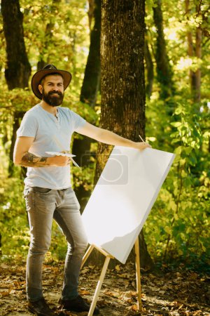 Photo for Drawing from life. Painter artist forest. Art concept. Painting in nature. Start new picture. Painter with easel and canvas. Capture moment. Bearded man painter looking for inspiration autumn nature. - Royalty Free Image