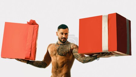 Photo for Huge presetn box. big shopping sale. brutal sportsman torso. steroids. sport and fitness, health. muscular macho man with athletic body. confidence charisma. sexy abs of tattoo man. male fashion. - Royalty Free Image