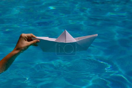 Photo for Paper ship in hand. Hand and paper boat. Tourism, travel dreams vacation holiday, dreaming traveling, sailing adventure - Royalty Free Image