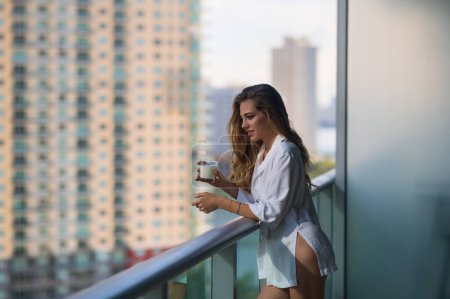 Photo for Morning healthy breakfast. Young woman with glass of milk on balcony terrace. Girl drinking milk at home. Beautiful woman holding milk glass. Lactose free milk, concept. Morning beverage - Royalty Free Image