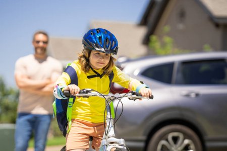 Photo for Father and son on the bicycle. Father and son riding a bike in summer park. Kid learning to riding bicycle. Father and son riding bikes wearing helmets. Child on bicycle outdoor. Fathers day - Royalty Free Image