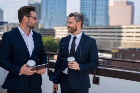 Photo for Two businessmen discussing outdoor during business meeting. Businessmen talking. Brainstorm with serious colleague. Confident business partners walking on street and talking. Business partners talking - Royalty Free Image