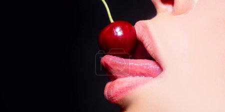 Cherry in woman mouth. Cherries on woman lips. Tongue lick cherry, macro, close up. Mouth lick cherry