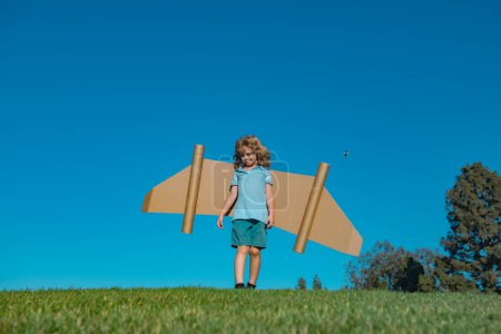 Téléchargez les photos : Pilote enfant avec jetpack jouet sur fond de ciel. Joyeux enfant jouant à l'extérieur. Bonne enfance - en image libre de droit