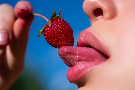 Foto de Fresa en labios sexys. Fresa roja en boca de mujer de cerca - Imagen libre de derechos