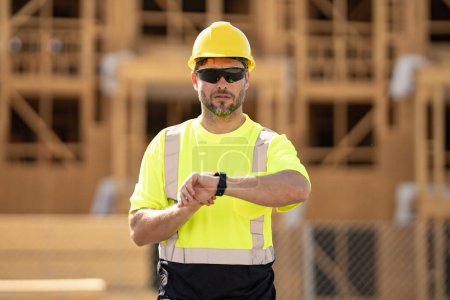 Photo for Construction man with helmet. Worker at construction new building. Builder at construction site. Foreman workman portrait. Builder in helmet outdoor portrait. American worker in hardhat - Royalty Free Image