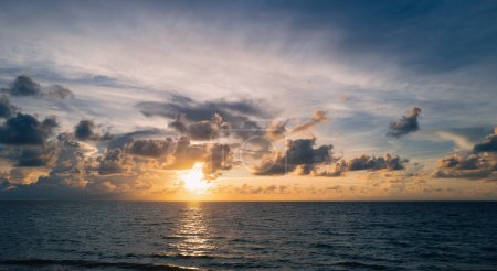 Foto de Paisaje marino atardecer. Colorido amanecer playa con olas tranquilas. Naturaleza cielo marino. Colorido amanecer de playa oceánica con cielo azul profundo y rayos de sol. Salida del sol con nubes de diferentes colores - Imagen libre de derechos