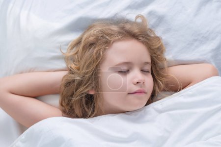 Téléchargez les photos : Enfant dormant au lit. Joli gosse dormant sous une couverture. Un gamin allongé sur un oreiller. Repos d'enfant endormi, dormir sainement ou faire une sieste - en image libre de droit