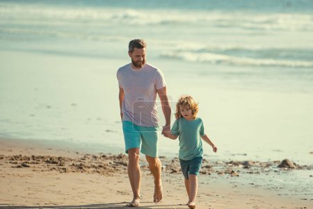 Téléchargez les photos : Père et fils marchent sur la mer. Papa et enfant s'amusent dehors. Voyage en famille, vacances, concept de fête des pères - en image libre de droit