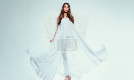 Foto de Concepto de San Valentín y vestuario. Mujer joven disfrazada de ángel. Ángel con regalo. Ángel blanco caído. Hermosa mujer posando con alas de ángel - Imagen libre de derechos