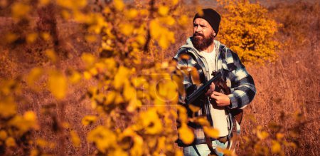 Foto de Temporada de caza de otoño. Hunter con escopeta a la caza. Caza de otoño - Imagen libre de derechos