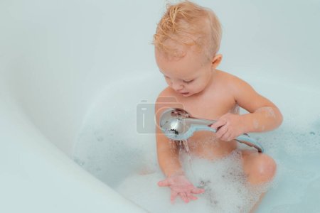 Photo for Happy little baby boy having fun to bath. Cute happy laughing baby in soft bathrobe after bath playing in kids room. Kids Hygiene and health care - Royalty Free Image