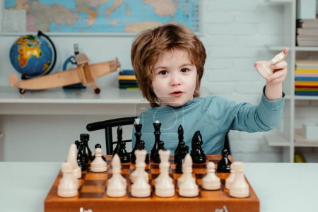 Téléchargez les photos : Petit garçon jouant aux échecs. Jeux éducatifs pour enfants, développement précoce - en image libre de droit