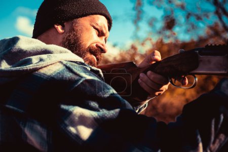 Foto de Apretó el gatillo de la escopeta. Cazador furtivo en el bosque. Hunter con escopeta a la caza. Gran juego - Imagen libre de derechos