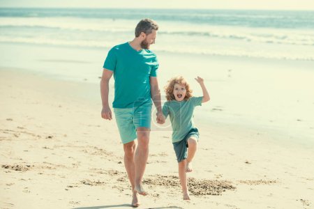 Téléchargez les photos : Père et fils qui courent sur la plage d'été. Papa et enfant jouant en plein air - en image libre de droit