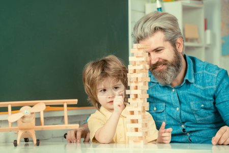 Photo for Happy father and son at the table playing board games. Learning and education concept - Royalty Free Image