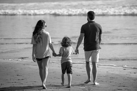 Photo for Back view of young happy family on the beach vacation - Royalty Free Image