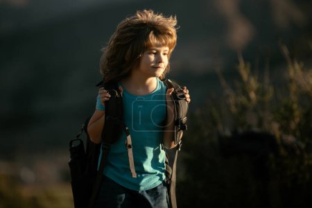 Photo for Kid with backpack hiking in scenic mountains. Boy local tourist goes on a local hike. - Royalty Free Image