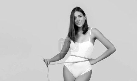 Photo for Young girl measuring her waist. Female fit slim body. Trained belly with measuring tape - Royalty Free Image
