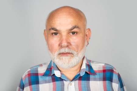 Foto de Cara de pensionista de 50 años. Viejo hombre mayor maduro con barba gris sobre fondo de estudio negro - Imagen libre de derechos