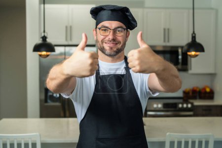 Téléchargez les photos : Joyeux chef cuisinier avec le pouce levé. Chef cuisinier boulanger. Chef masculin millénaire en uniforme de chef. Chef homme cuisine gon - en image libre de droit