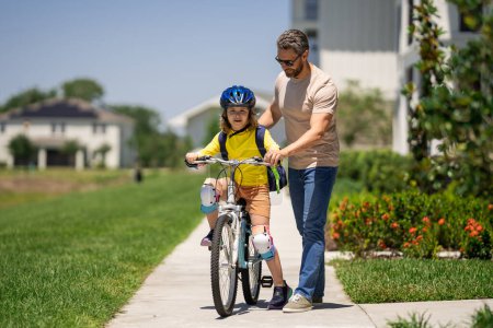 Photo for Happy Fathers day. Father and son in a helmet riding bike. Little cute adorable caucasian boy in safety helmet riding bike with father. Family outdoors summer activities. Fathers love - Royalty Free Image