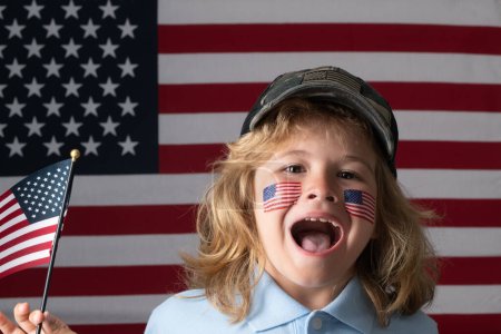 Téléchargez les photos : Drapeau américain sur la joue de l'enfant, jour de l'indépendance 4 juillet. Concept des États-Unis d'Amérique. Le 4 juillet, jour de l'indépendance des Etats-Unis. Portrait d'un enfant patriote américain. drôle étonné enfants visage - en image libre de droit