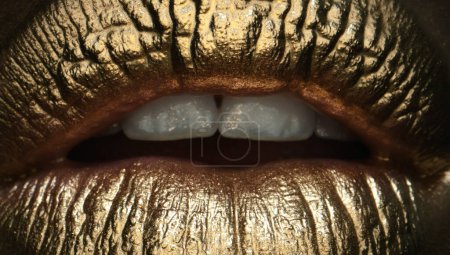 Foto de Cosmética glamurosa. Labios dorados, brillo de labios dorados en labios sexys, boca metálica. Belleza mujer maquillaje de cerca - Imagen libre de derechos