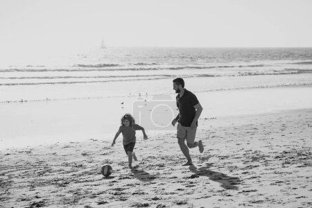 Photo for Father and son play soccer or football on the beach. Happy family concept - Royalty Free Image