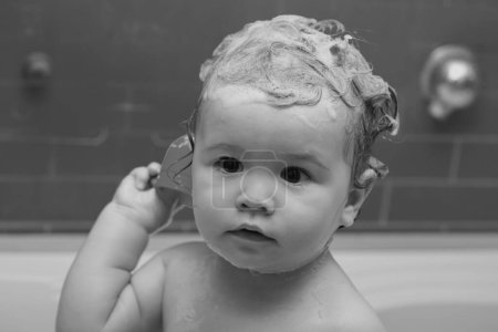 Foto de Sonriendo hermoso bebé bañándose en la ducha. Feliz bebé divertido bañado en el baño - Imagen libre de derechos