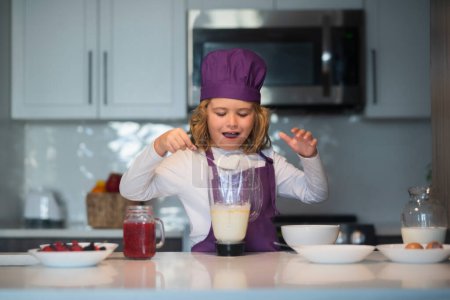 Téléchargez les photos : Repas de cuisinier enfant. Chef enfant dans tablier et chapeau de chef cuisinier à la cuisine. Aliments sains - en image libre de droit