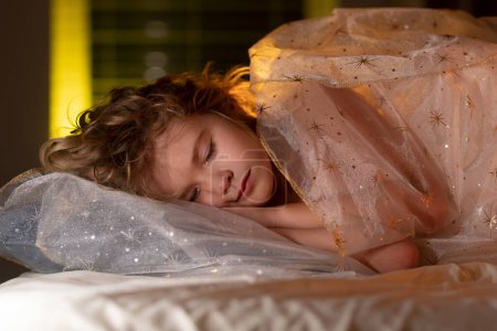 Téléchargez les photos : Un gamin qui fait de beaux rêves. Enfant dormant sur le lit à la maison. Au lit, gamin dort. Enfant garçon endormi sur un oreiller doux avec couverture - en image libre de droit