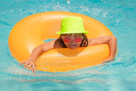 Photo for Summer fun. Child boy swim with floating ring in swimming pool. Kids summer vacation. Happy little boy with inflatable ring in poolside - Royalty Free Image