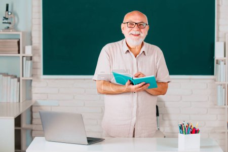Photo for Senior teacher in the classroom on blackboard background. Old professor in high school or university. Teachers day - Royalty Free Image