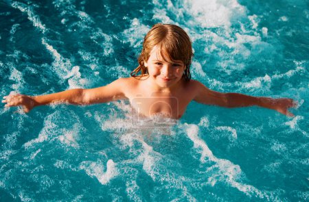Téléchargez les photos : Un gamin nage. Vacances d'été pour enfants dans la piscine - en image libre de droit