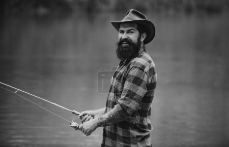 Téléchargez les photos : Homme avec canne à pêche, pêcheurs en plein air dans l'eau de la rivière. Passe-temps de pêche d'été - en image libre de droit