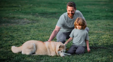 Foto de Padre e hijo con perro en el parque. Concepto de estilo de vida familiar feliz - Imagen libre de derechos