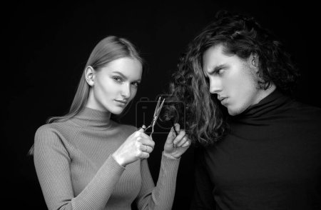 Photo for Couple with scissors cut hair. Portrait of young man and woman with a scissors cutting male curly hair. People hair care and beauty - Royalty Free Image