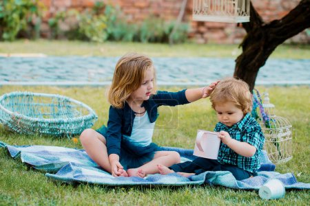Photo for Children on pirnic. Lifestyle portrait baby child in happines at the outside in the meadow. Brother and sister play together in a green meadow - Royalty Free Image