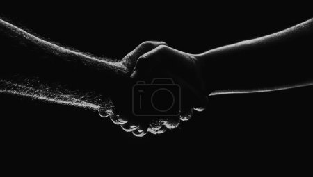 Téléchargez les photos : Une poignée de main entre les deux partenaires, d'accord. Sauvetage des mains masculines. poignée de main amicale, salutation d'amis, amitié. Sauvetage, geste d'aide ou mains. Aide à la main - en image libre de droit