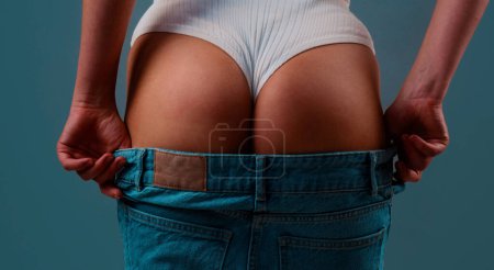 Photo for Sexy woman taking off jeans. Great ass. Sexy female wearing a of pants. Sexual girl takes off her jeans. Seductive woman, shows a beautiful ass, butt. Sexy woman body in jean, stripper - Royalty Free Image