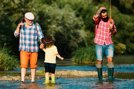Téléchargez les photos : Fishing with son and grandson. Grandfather and father with cute child boy are fishing - en image libre de droit