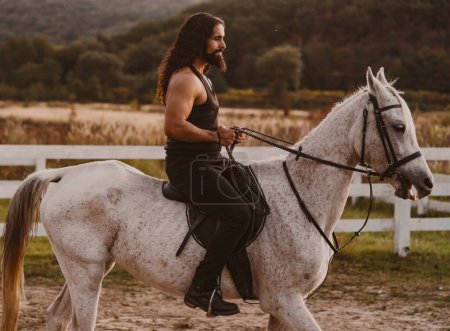 Téléchargez les photos : Handsome muscular man riding horse. Man ride horse on farm. Young jockey training his horse for a ride - en image libre de droit