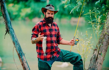 Téléchargez les photos : Portrait d'un pêcheur utilisant la canne à pêche volante dans une rivière de montagne. Un pêcheur à la mouche pêche la truite sauvage sur la rivière dans la forêt. Vacances de printemps - en image libre de droit