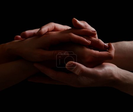 Foto de Concepto de salvación. Las manos de dos personas rescatan, ayudan. Mano amiga, apoyo. Brazo aislado en negro, caridad. Dedicado y empático. Relación de pareja - Imagen libre de derechos