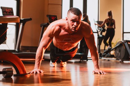 Photo for Sport man doing push ups exercise, pushup crunch. Portrait of young athlete doing exercise with dumbbell at the gym. Crossfit, sport and healthy lifestyle concept - Royalty Free Image