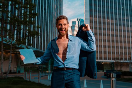 Photo for Excited businessman celebrating successful ending hard work, make deal dancing near office raised hands feels happy. Lucky applicant, after job interview - Royalty Free Image