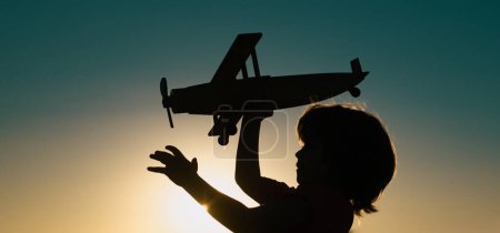 Photo for Kids playing with vintage wooden airplane outdoors. Portrait of children against summer sunset sky background. Travel and freedom concept. Cute kids face - Royalty Free Image
