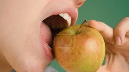 Téléchargez les photos : Concept dentaire. Dents blanches saines ferment avec une pomme - en image libre de droit