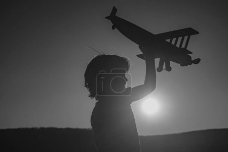 Photo for Child pilot aviator with airplane dreams of traveling on sunset - Royalty Free Image
